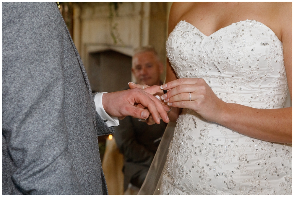 Bride puts ring on grooms finger